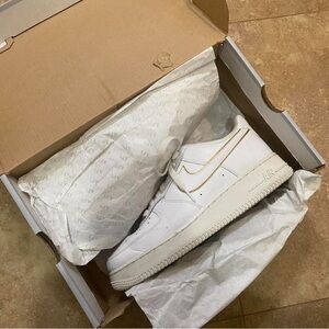 White Nike Air Force 1s with gold